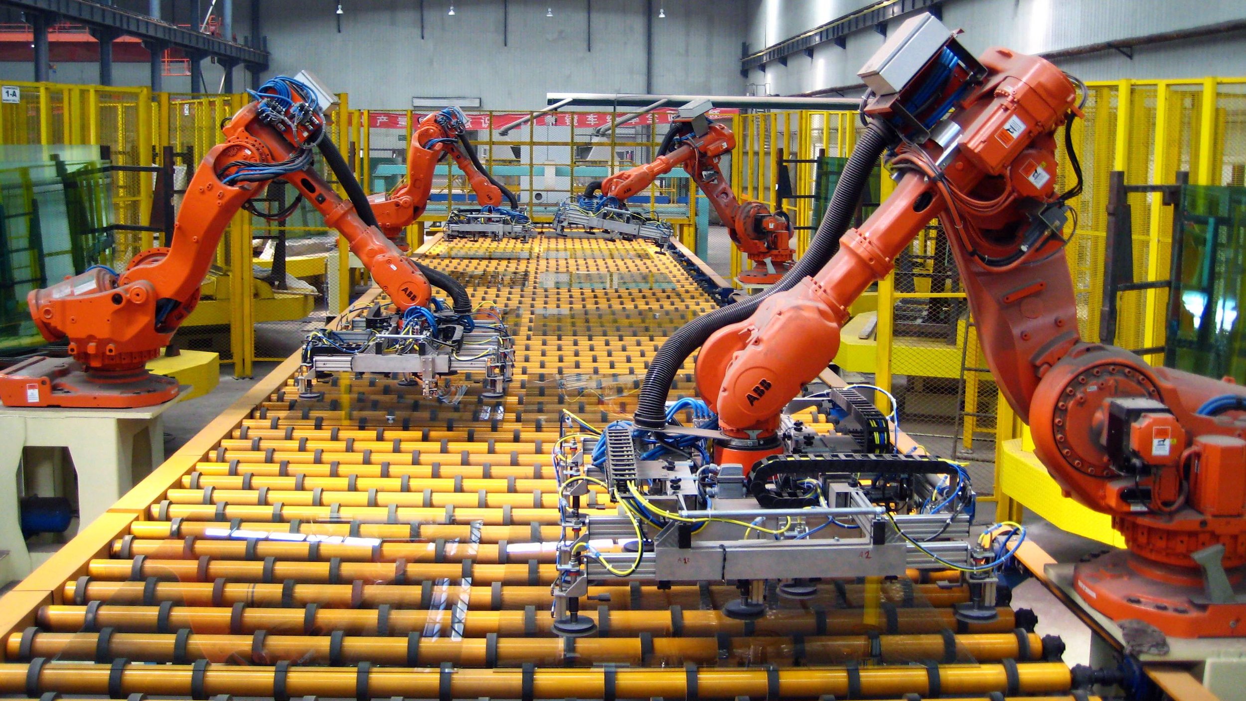 Large pieces of plate glass are unloaded by robotic arms in a factory in UK. Photo source: Getty Images .