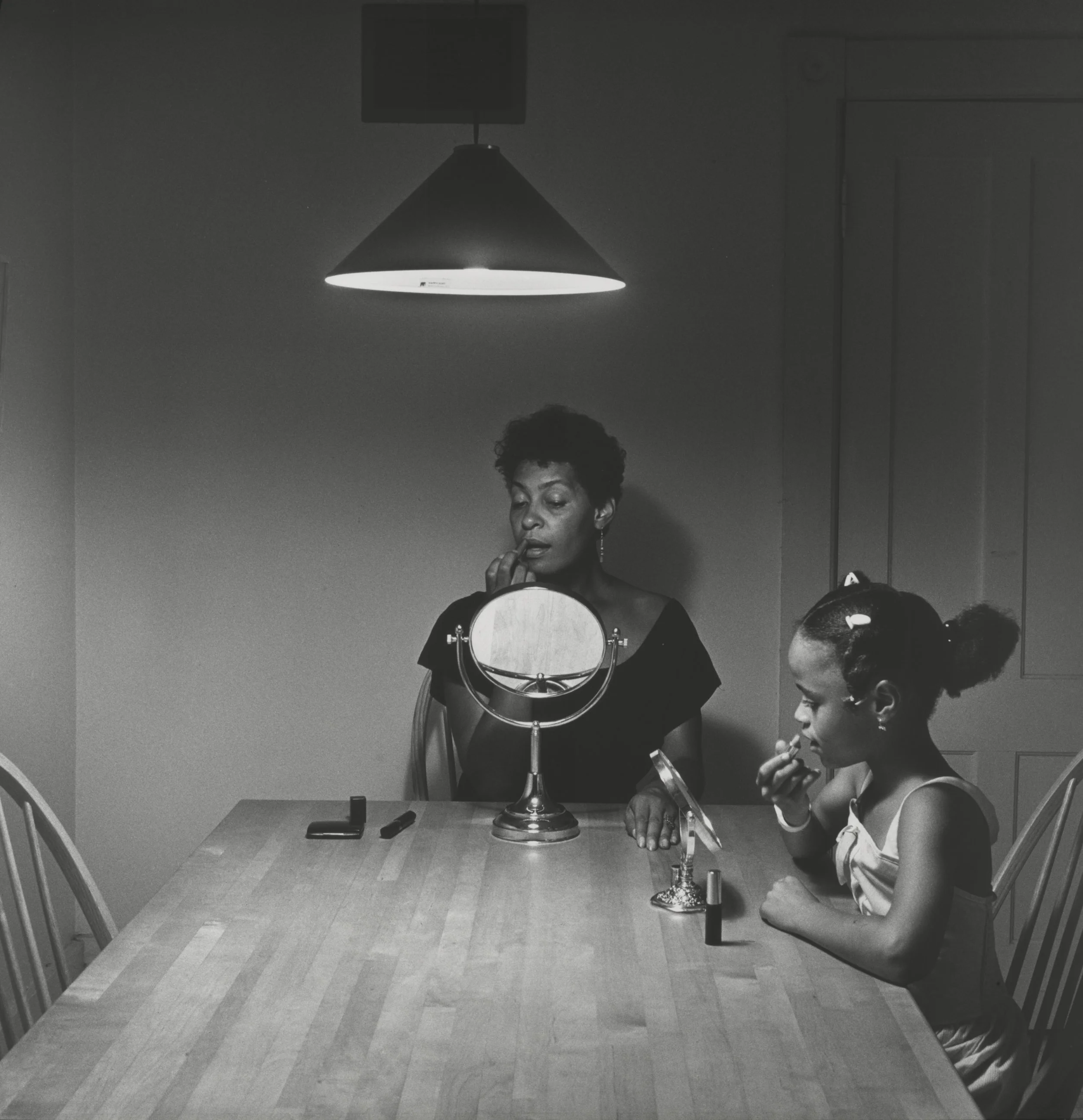 Woman and daughter with makeup from Kitchen Table series, 1990 by Carrie Mae Weems.
