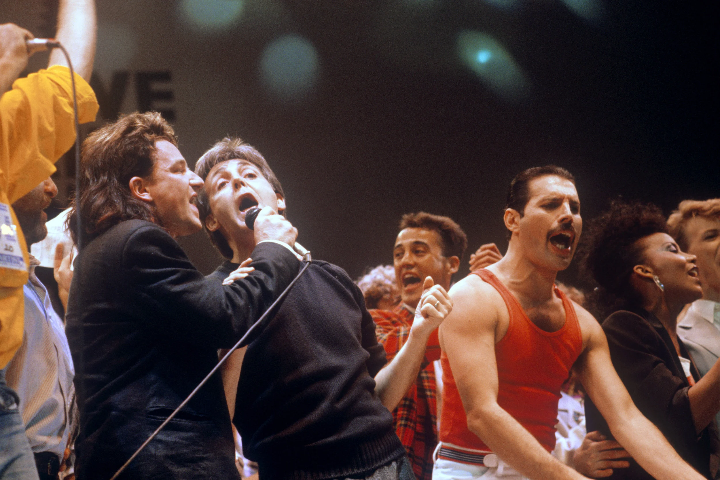 Bono, Paul McCartney, and Freddie Mercury performing at Live Aid concert, 1985.