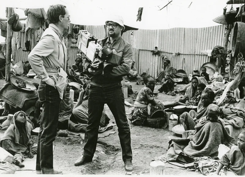 Michael Buerk and Mohamed Amin reporting the Ethiopian Famine, 1984. Photo source: Hurst Publisher.
