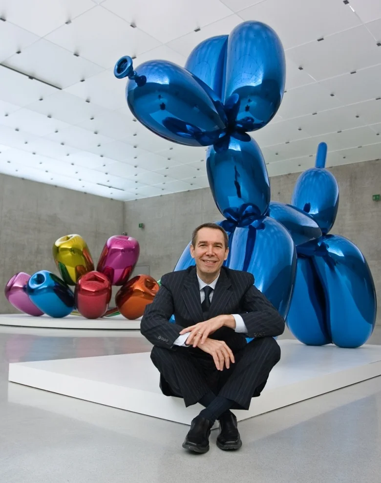 Jeff Koons poses with his sculpture ''Balloon Dog (Blue)'' at the Kunsthaus in Bregenz, 2017. Photo by Miro Kuzmanovic for Reuters .