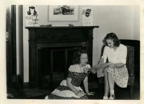 Betty Cue, a stenographer at the Memorial Union, showing a Curtiss P-40 Warhawk model plane to a cadette, 1943. Photo source: Iowa State University Archive.