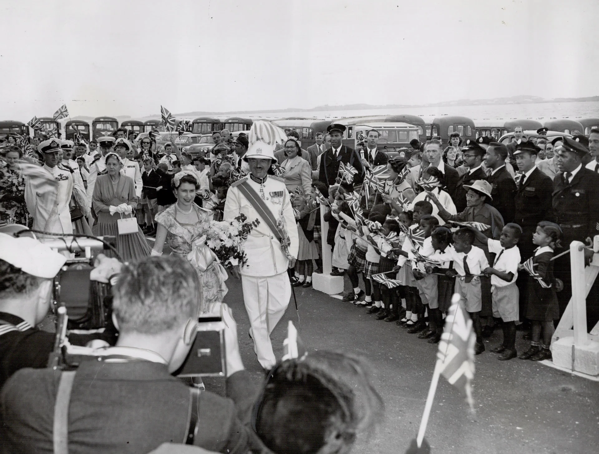 The Queen accompanied by Sir Alexander Hood, Governor of Bermuda is greeted by flag-waving children, 1953. Photo source: Virtual Reference Library.