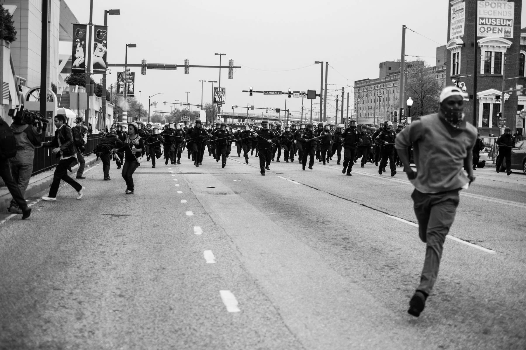 Devin Allen’s image of a man running from a phalanx of Baltimore Police.