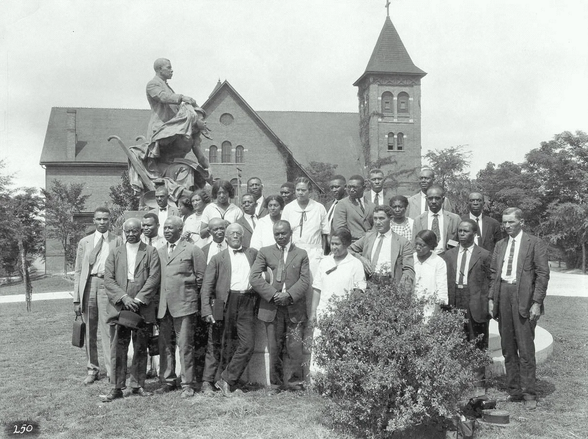 African-American farm and home demonstration agents pose for a group photograph under the Booker T. Washington monument at Tuskegee Institute, July 15, 1925: Wikipedia