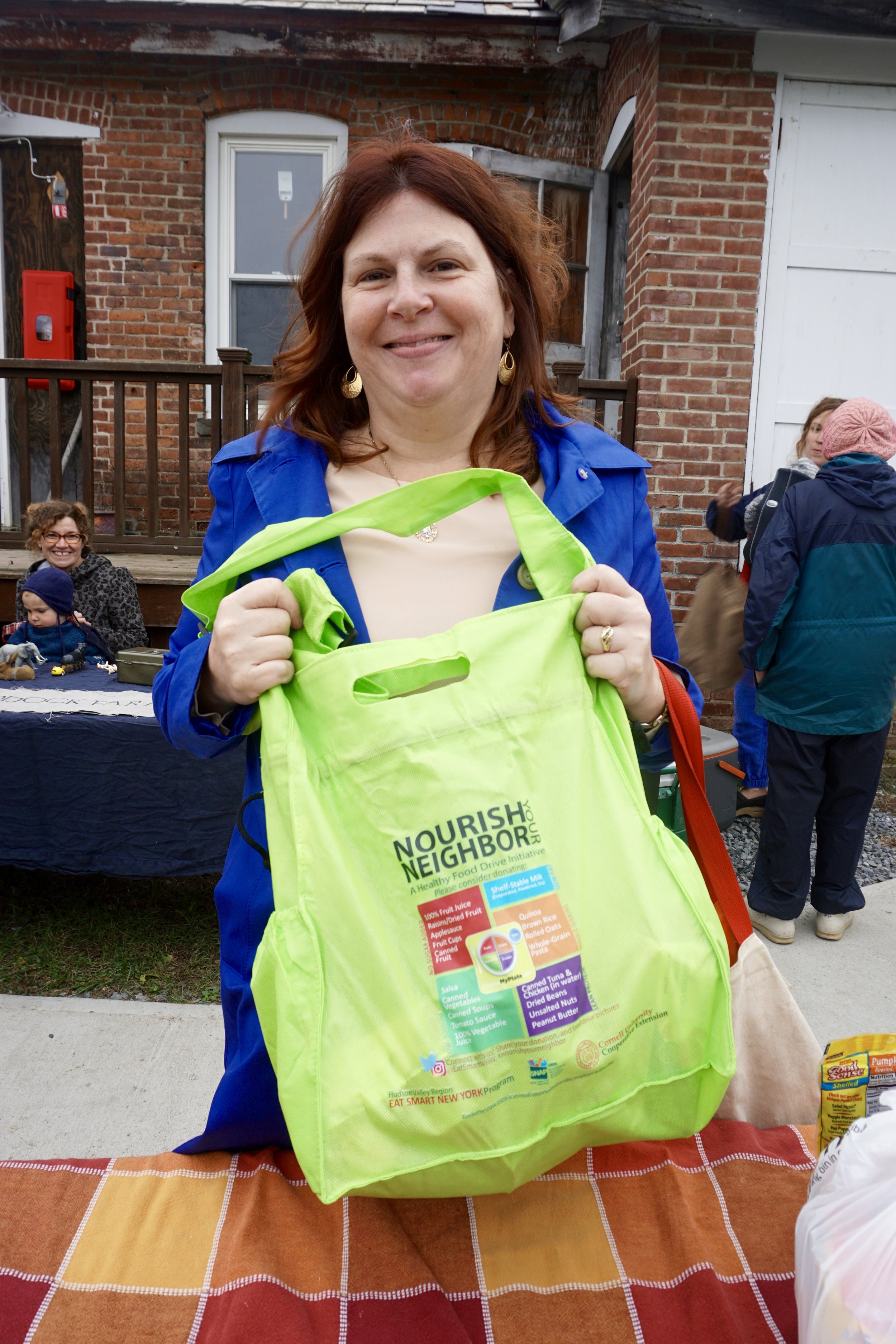  Mary Ficht, Teacher at Warring School, drops off a bag of healthy shelf-stable items for the Nourish Your Neighbor Food Drive 