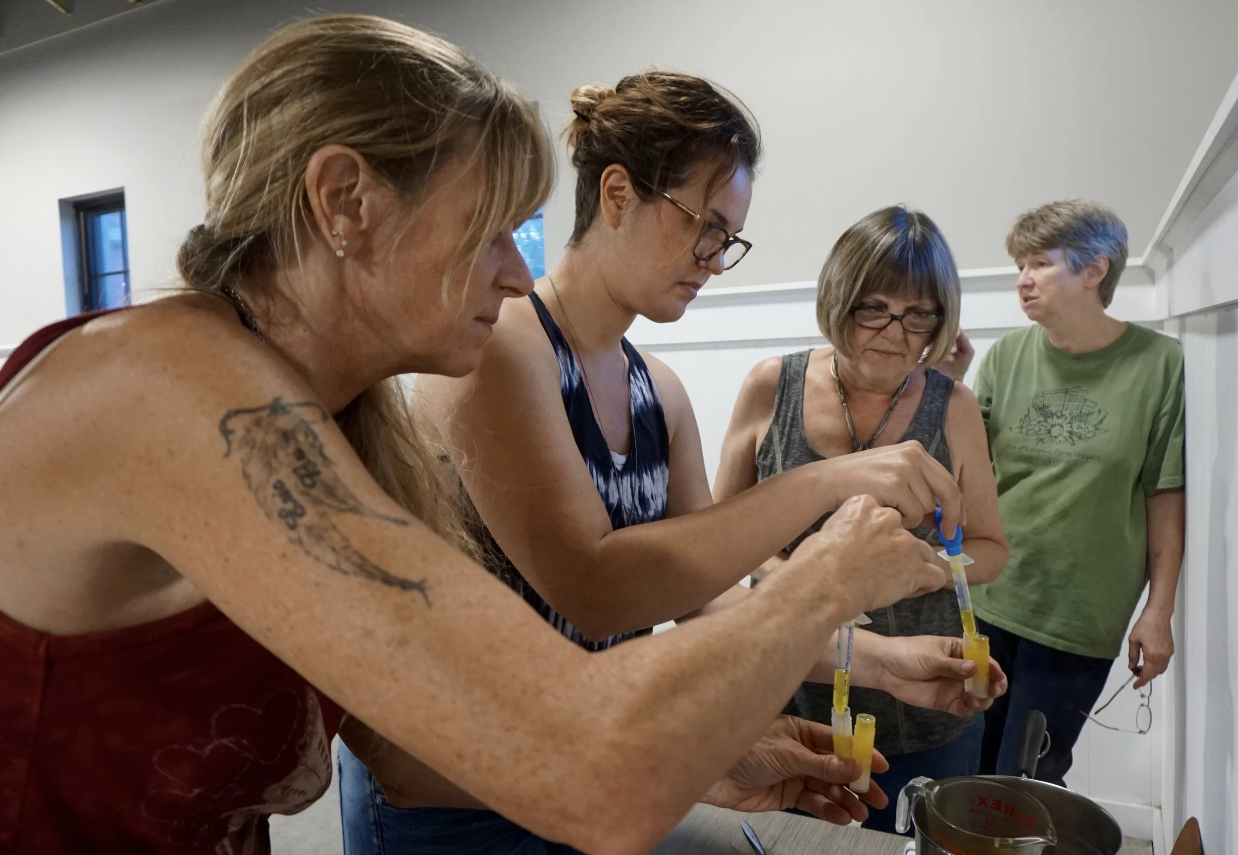 Above: workshop participants filling their lip balm tubes with the calendula infused oil, beeswax and peppermint essential oil mixture