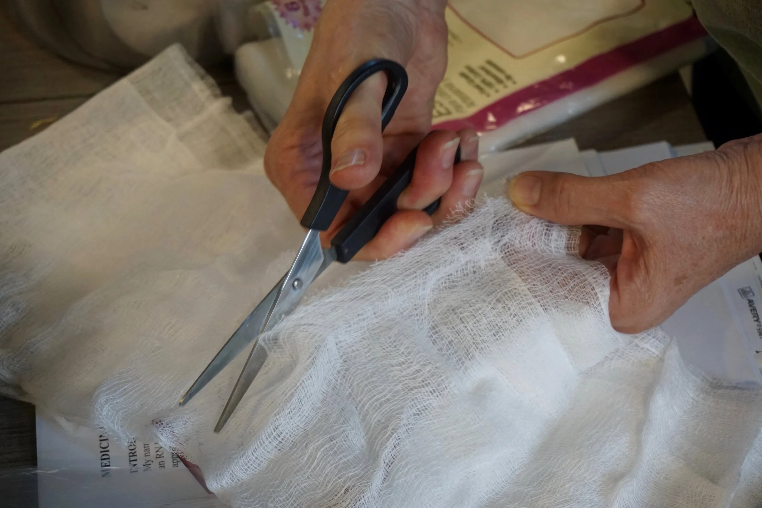 Above: cheese cloth being cut to filter the infused oils