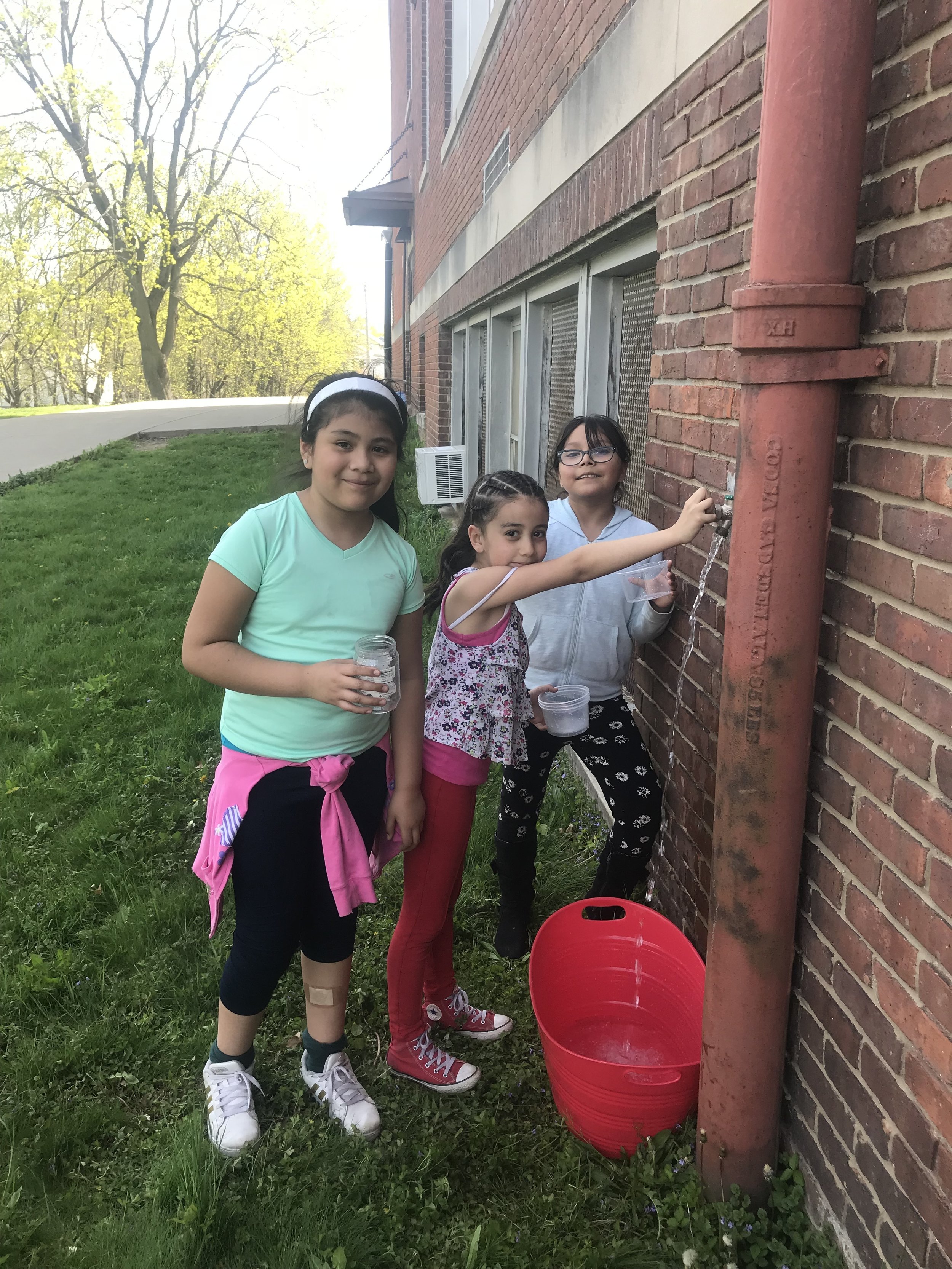  Morse students fill a bucket of water for the garden. 
