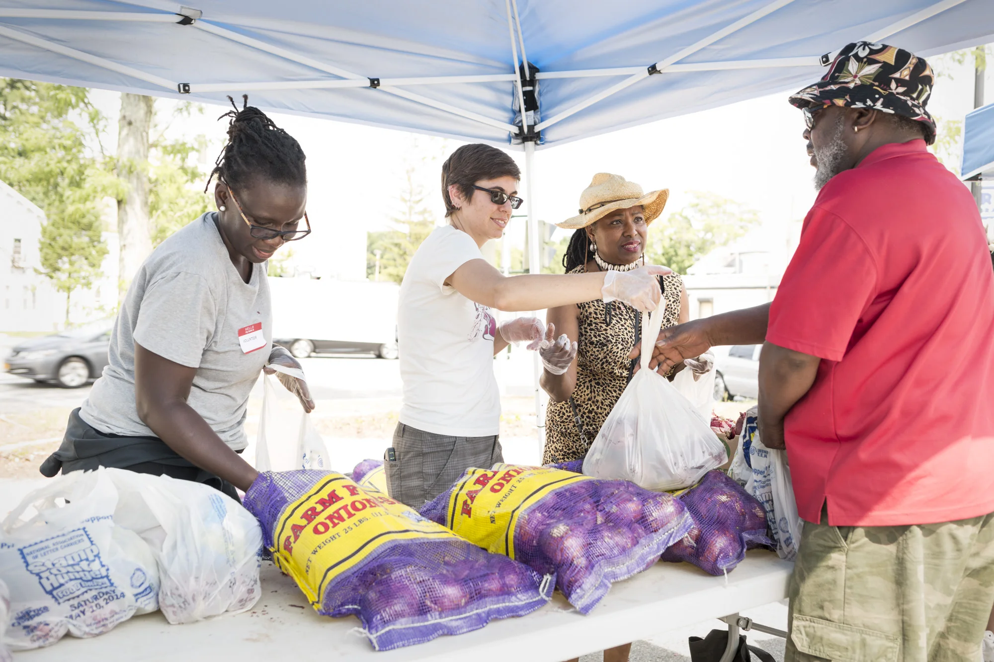 Bintou Hinds, Jamie Levato, and Ozie Williams distribute produce at Dutchess Outreach's Free Farm Stand. Photo credit: Sean Hemmerle
