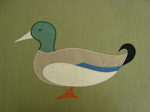 A dignified mallard duck, shown above in natural, jade, tangerine, blue & ecru on sage - a festival of colors! Mallard applique is 11" wide. $50.00 per motif.