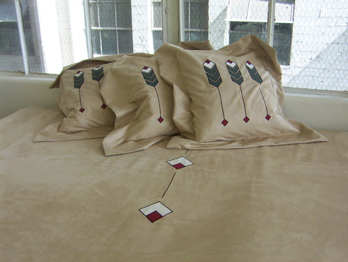 Flanged pillows and a bedspread made with our custom color Peasant Linen - Barley. The applique is an adaptation of our Prairie Grass design.