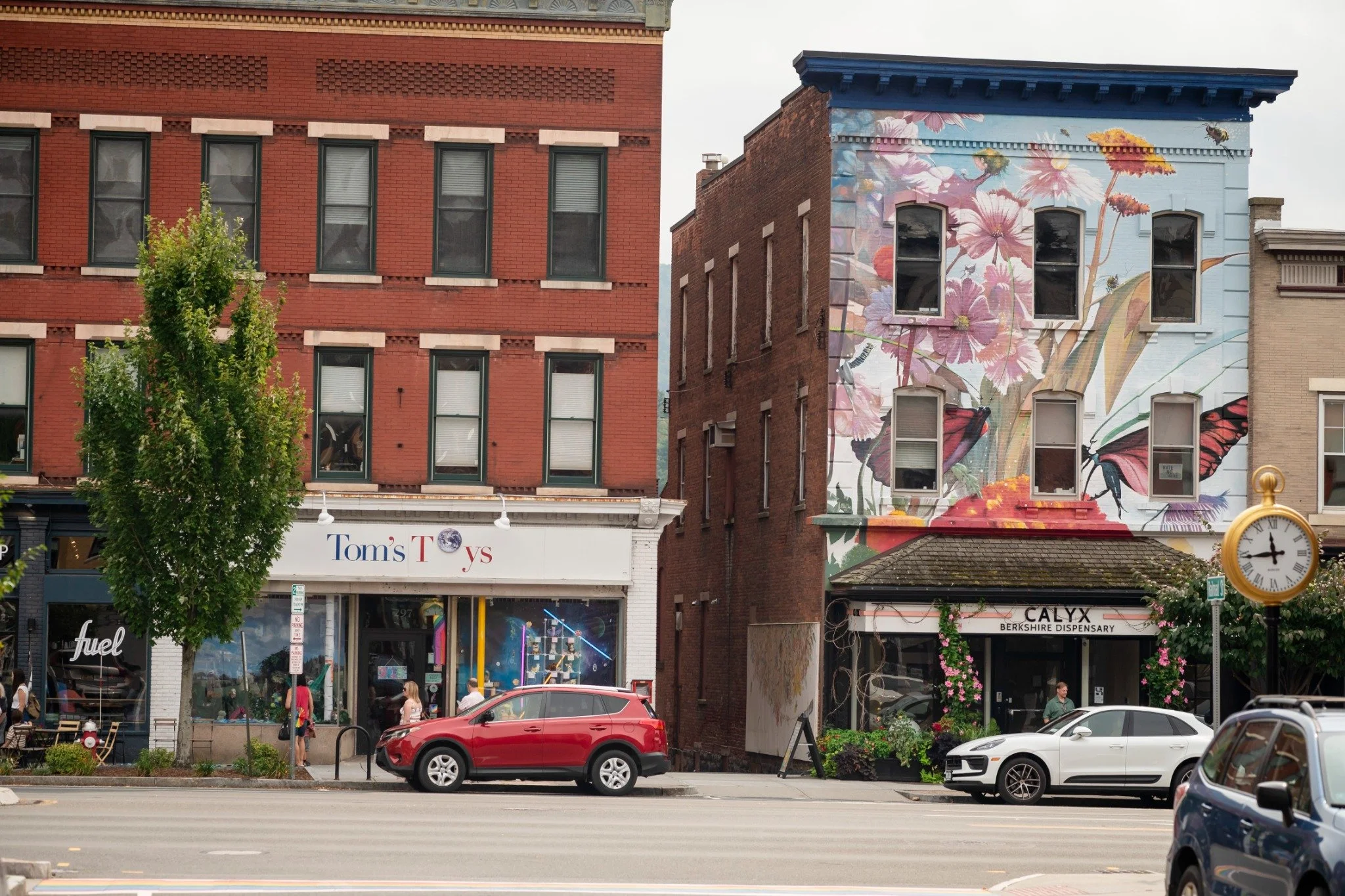 Great Barrington storefronts, street clock, and colorful flower mural