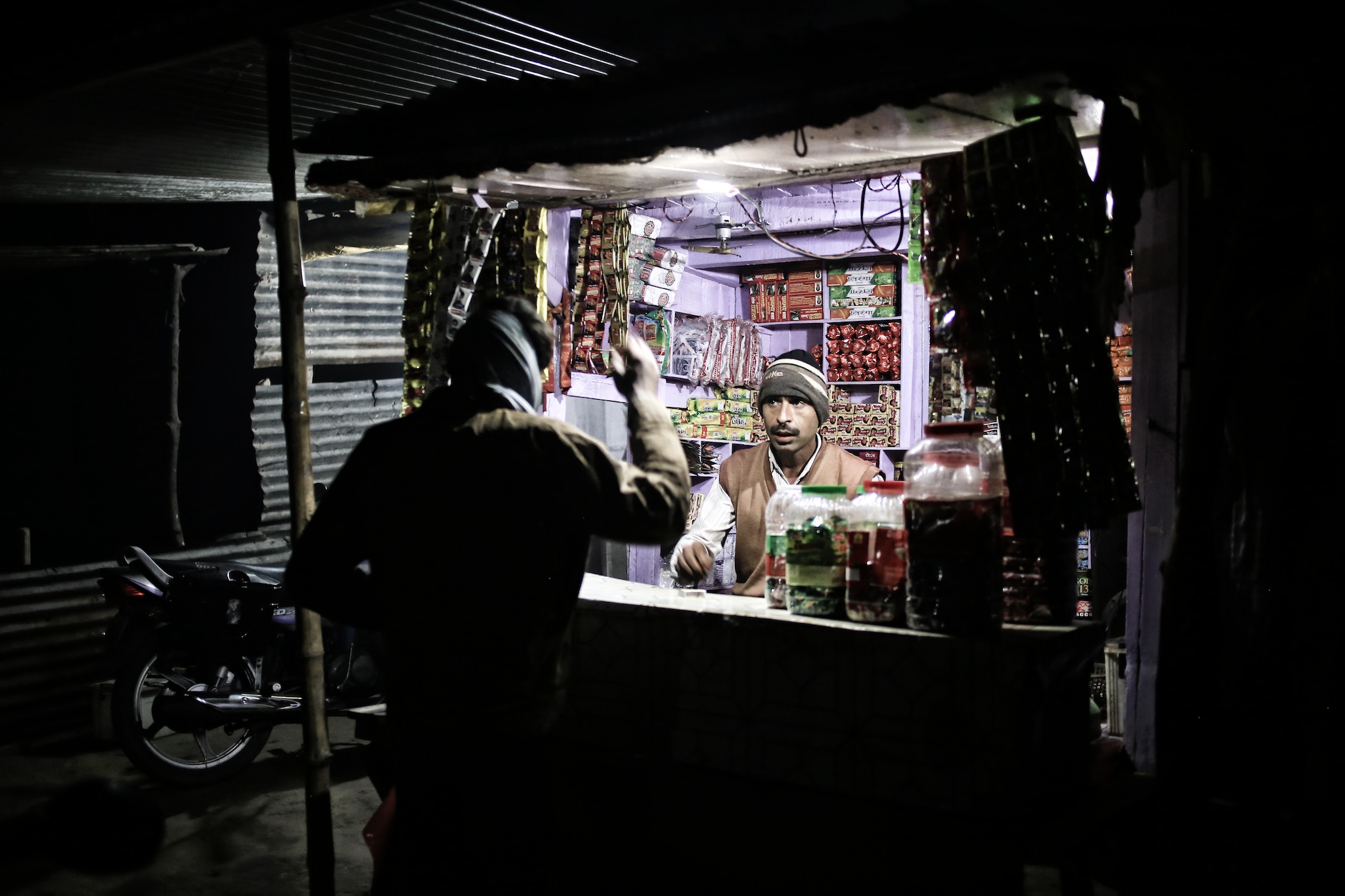 Small kiosk lit up by microgrid solar. Photo via SunFunder