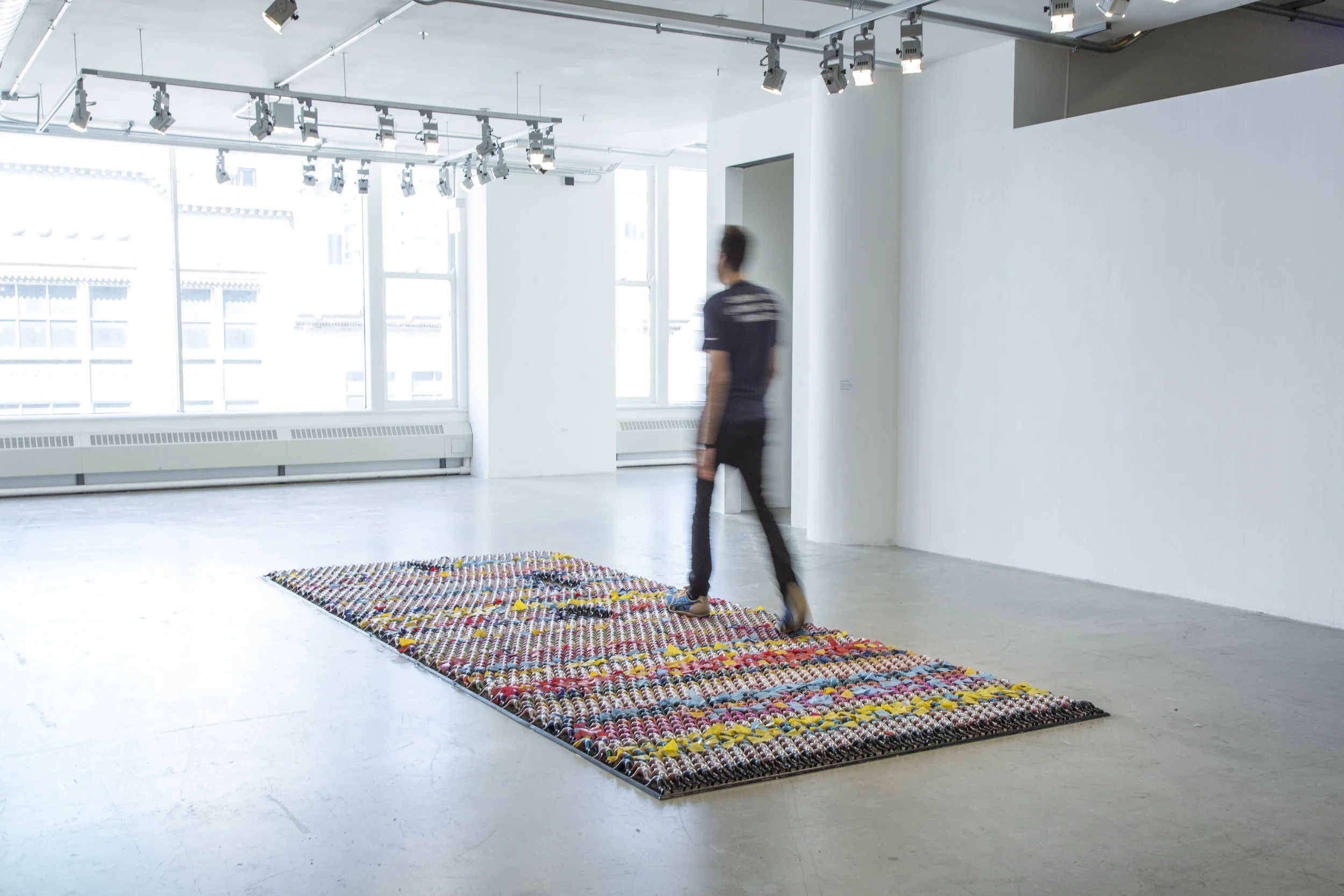 Floor Piece (one minute on/one minute off) 2017 15ft x 6ft 4,410 hand casted PVC dolls, enamel paints, plastic cloth, rubber nosing