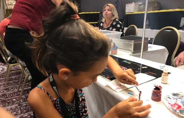The Paint-and-Take involves getting a free miniature, and access to paints and brushes. Gretchen in the background with the assists!