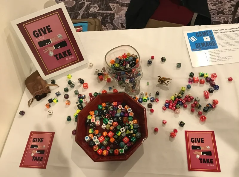 Give a die, Take a die. It’s a concept I stole from Big Bad Con 2018. My partner J made the wonderful card design!