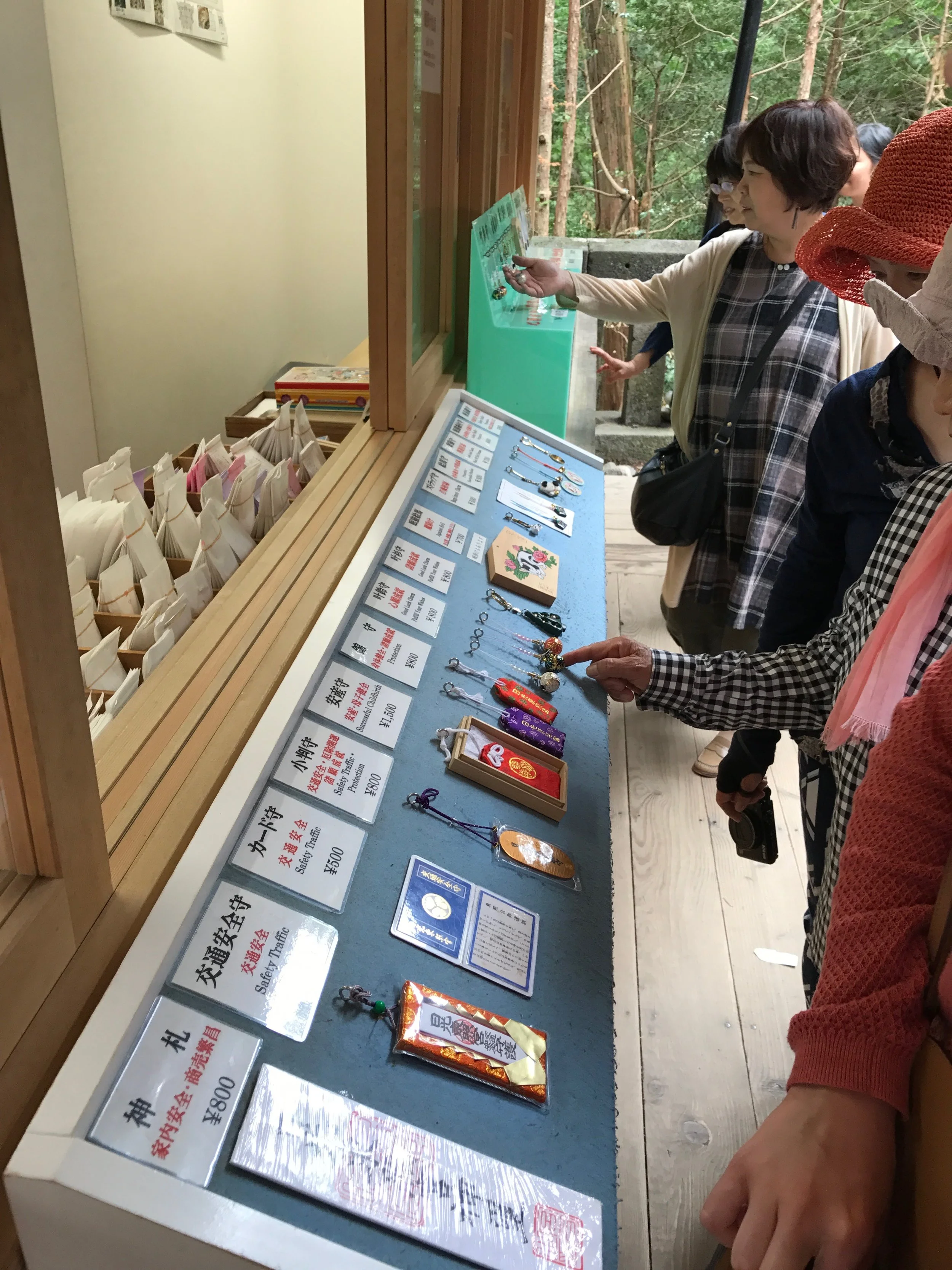 Omamori being advertised (upper left) and for sale (right) at Tôshôgû in Nikkô. The famous Hear No Evil, Speak No Evil, and See No Evil monkeys are carved in the sacred stable at the shrine (lower left).