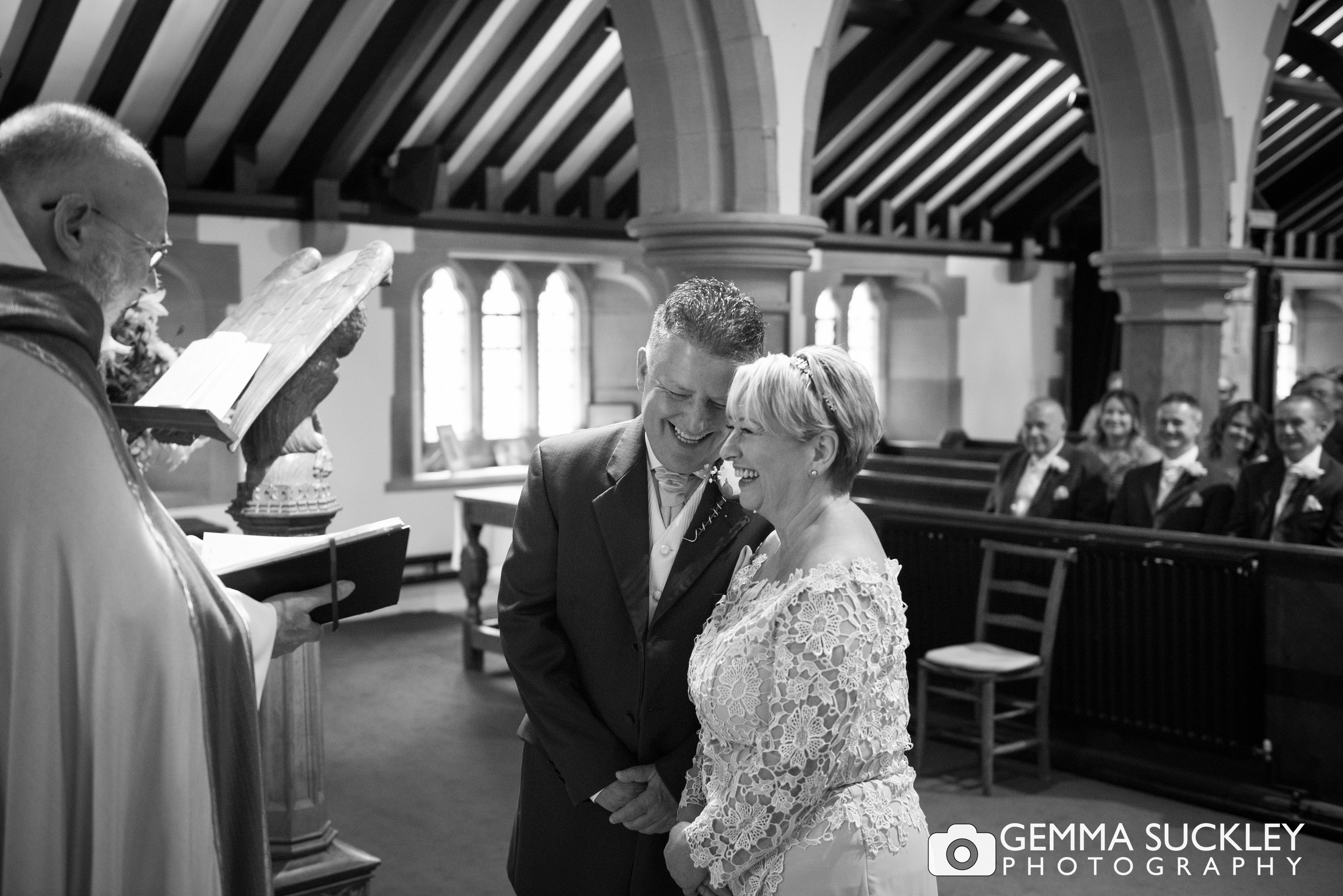 bride and groom giggling at the alter