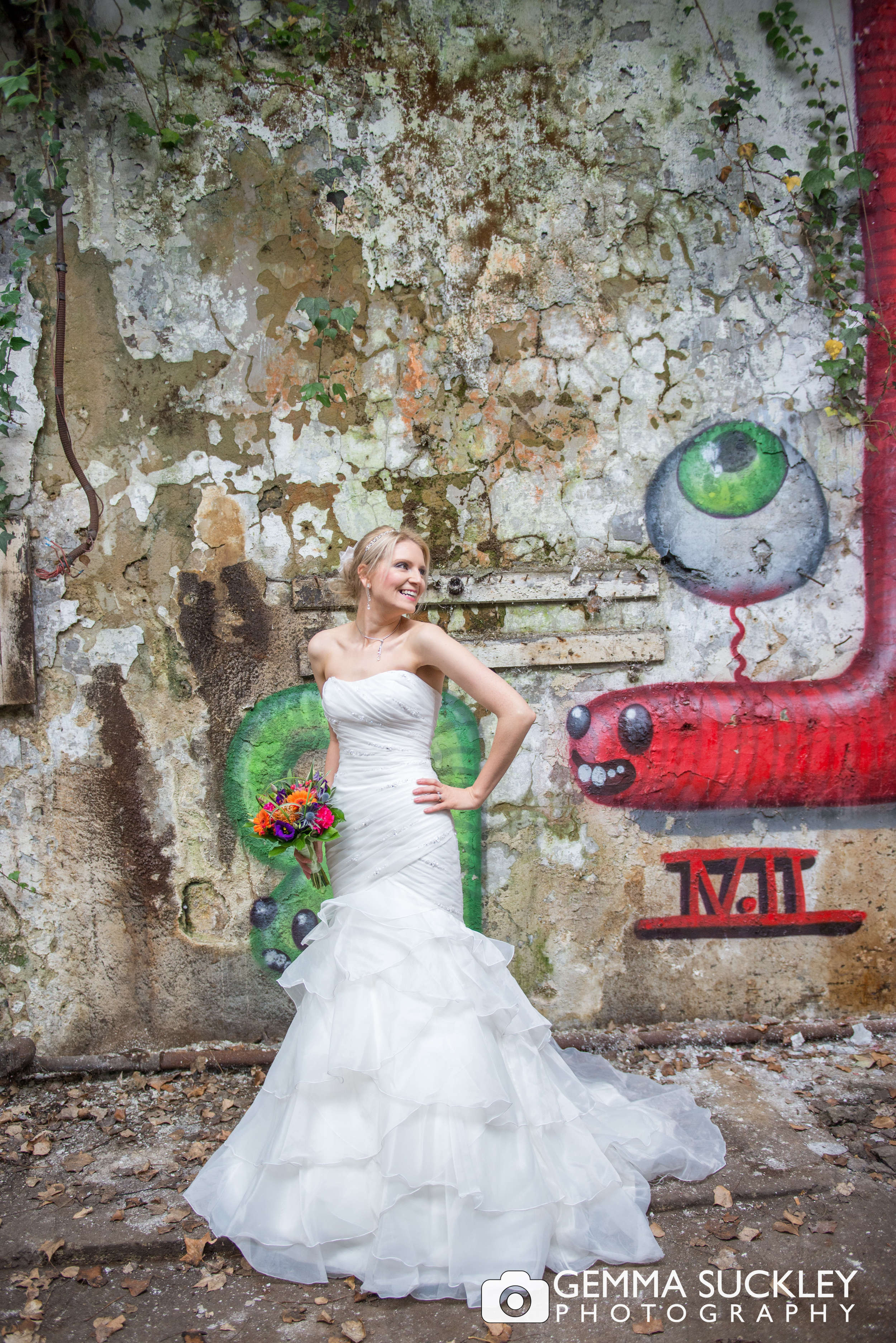 bride posing with graffiti behind her