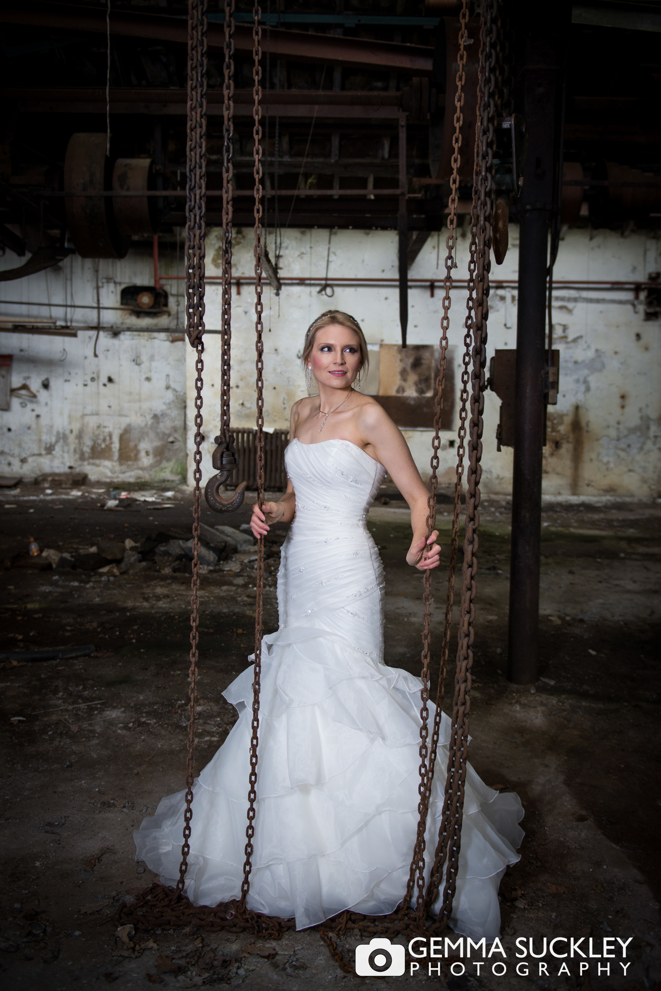bride posing in a dirty abandoned mill