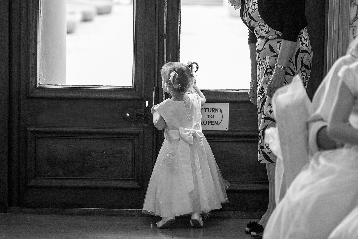 flower girl peeking out the window during a wedding
