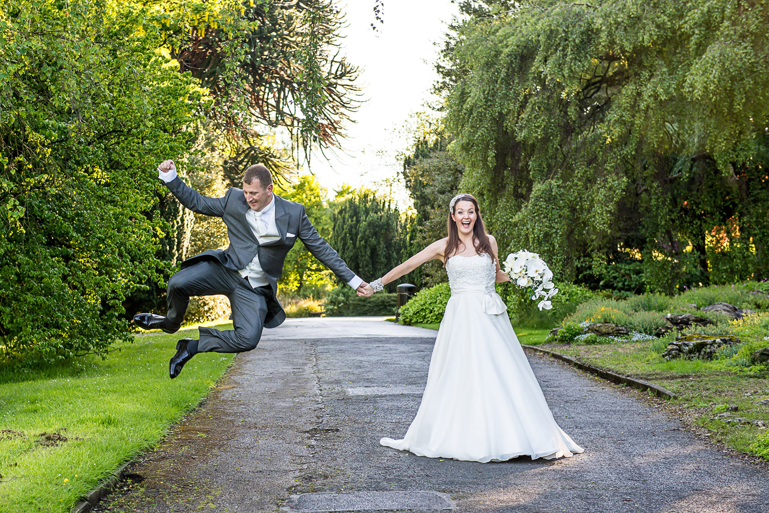 A Bride and Groom jumping in valley gardens in harrogate