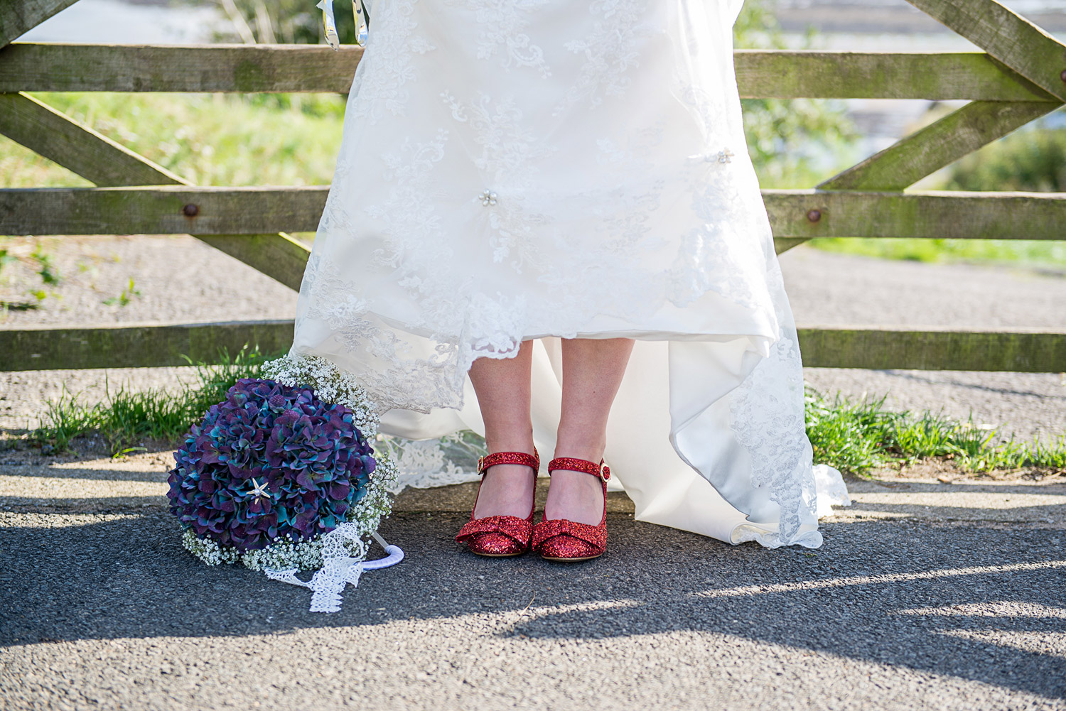 close up photo of vintage red wedding shoes and flowers