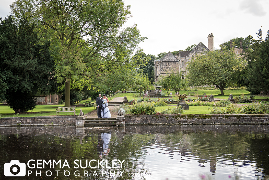 bride and groom by the lake at Monk Fryston Hall Hotel on their wedding day