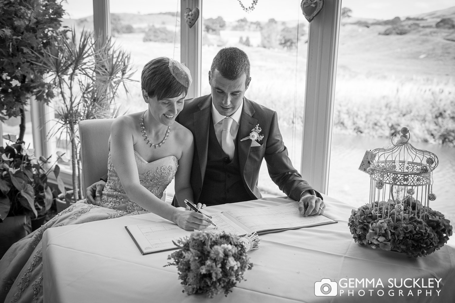 newly-weds signing the wedding register in rendezous