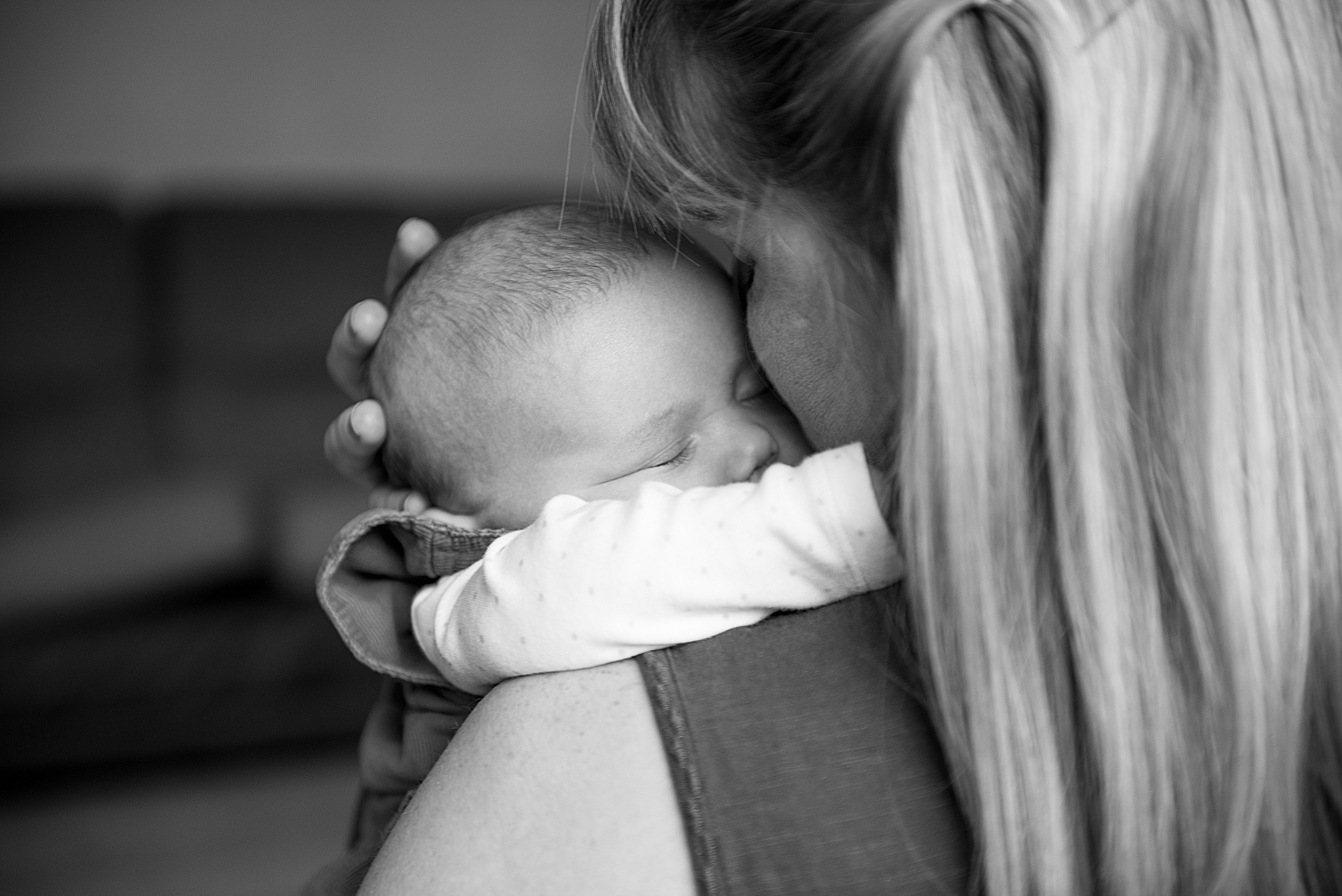 Black and white newborn photo of mum cuddling her baby