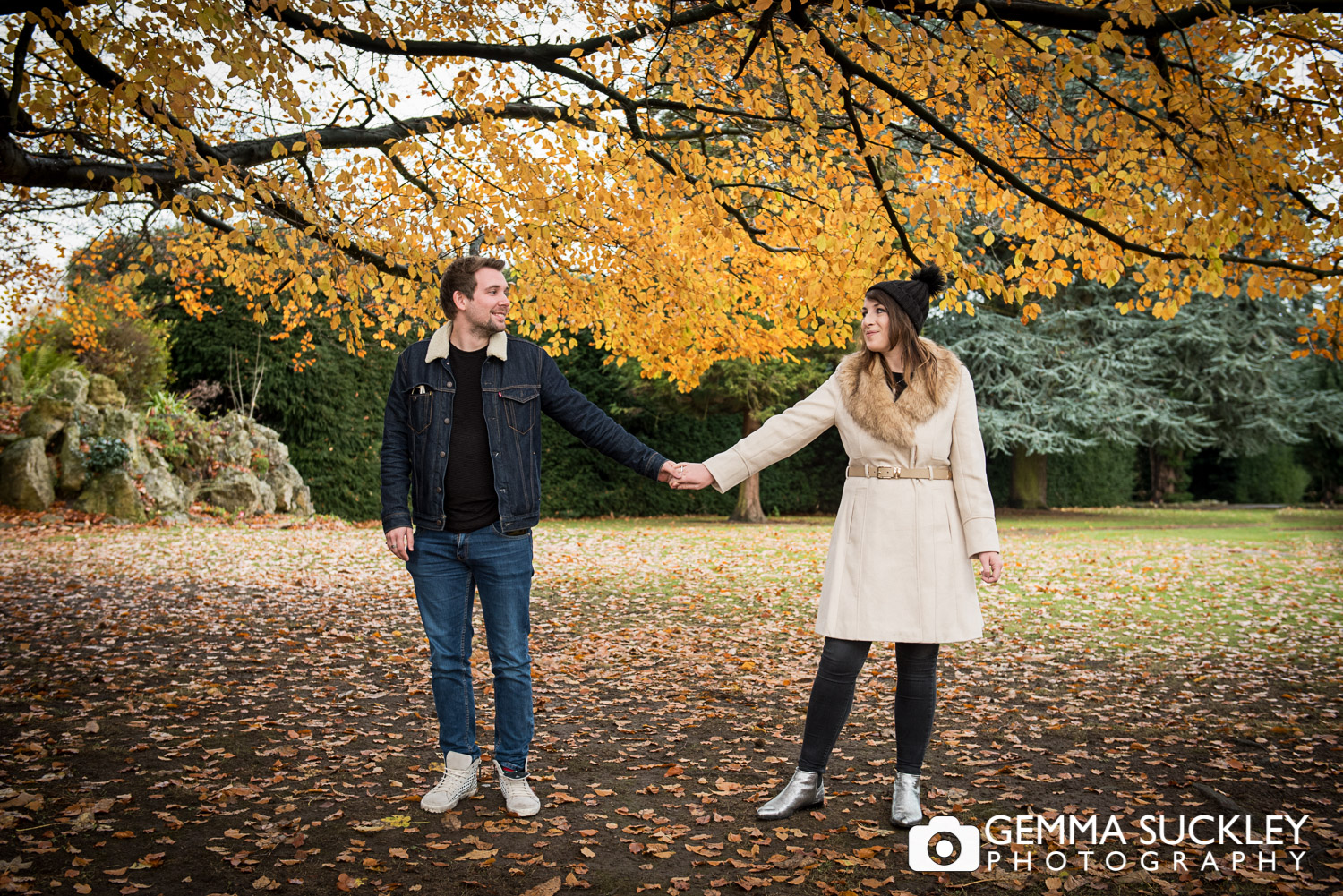 A couple holding hands in autumn at Hazlewood Castle