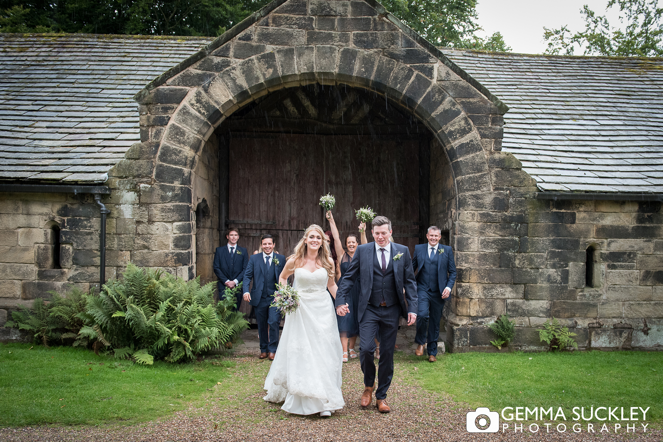 bride and groom in the rain at east riddlesden hall
