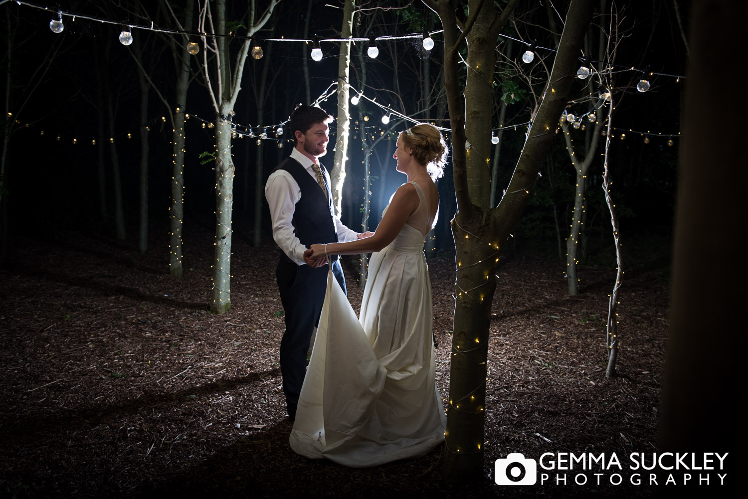 bride and groom surrounded by back-lit fairy lights