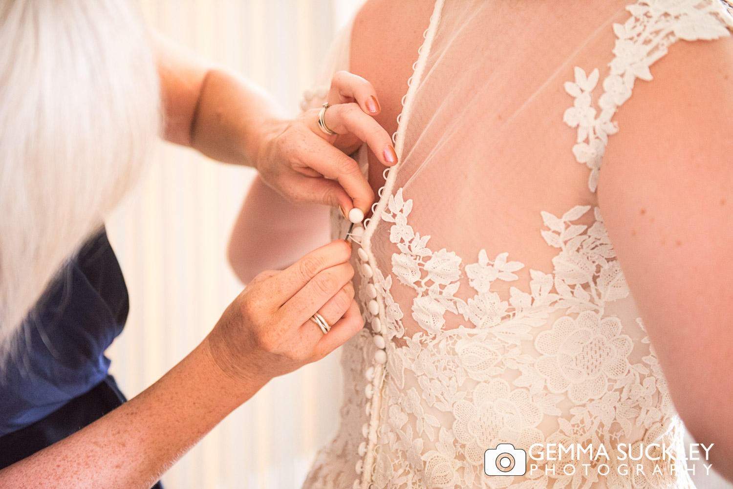 wedding dress buttons being buttoned up