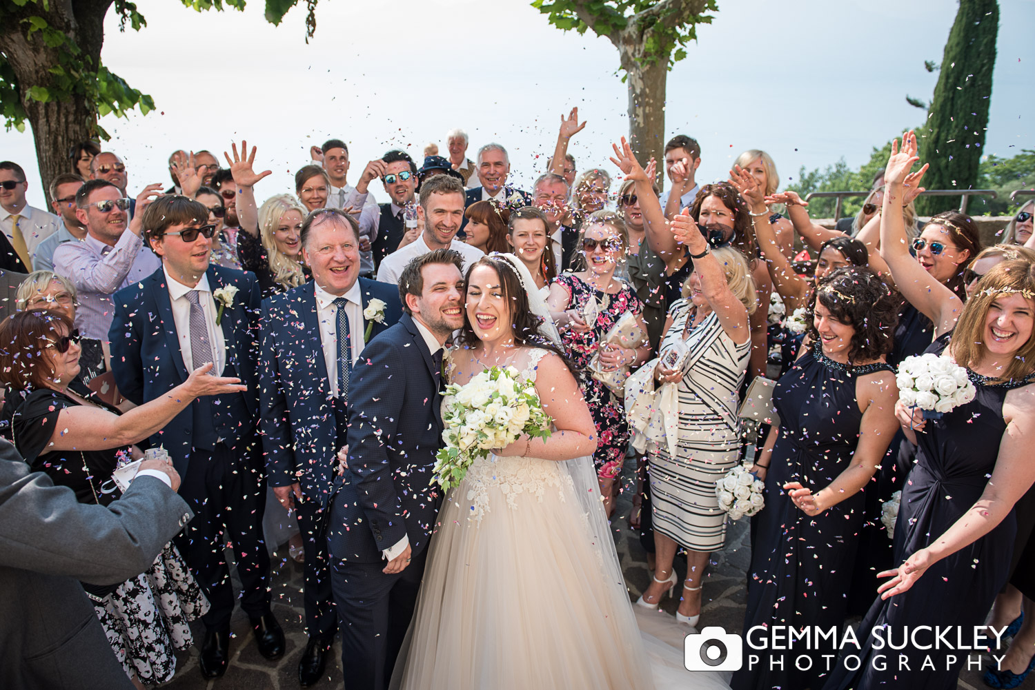 wedding guests throwing confetti at bride and groom 