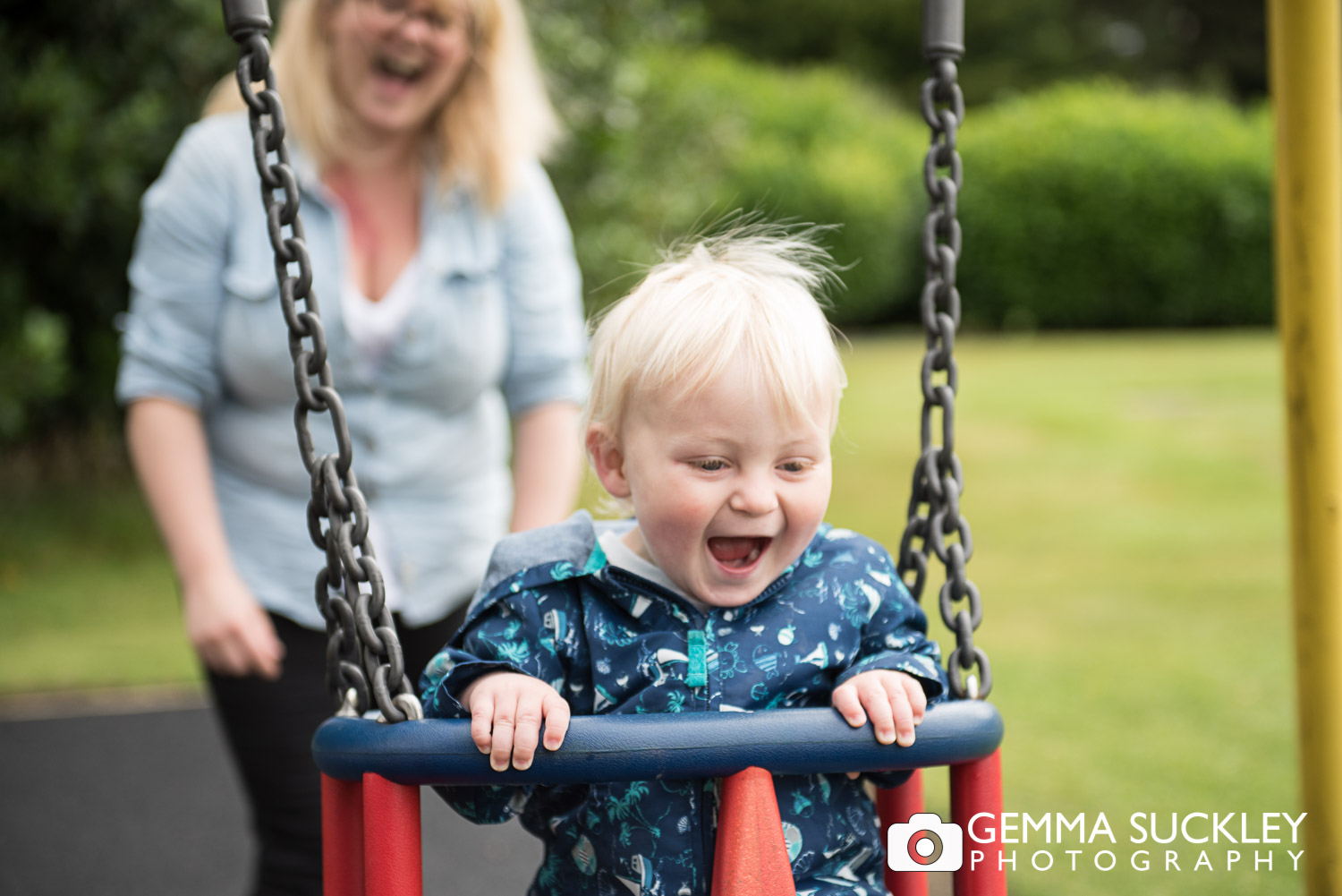 Little boy being pushed on a swing