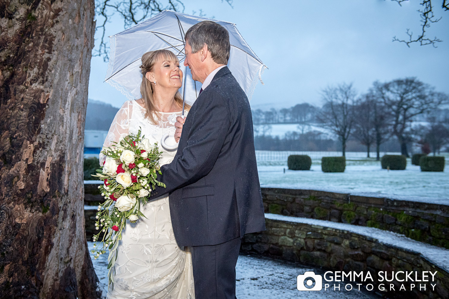 bride and groom in the snow outside The Devonshire arms in bolton Abbey