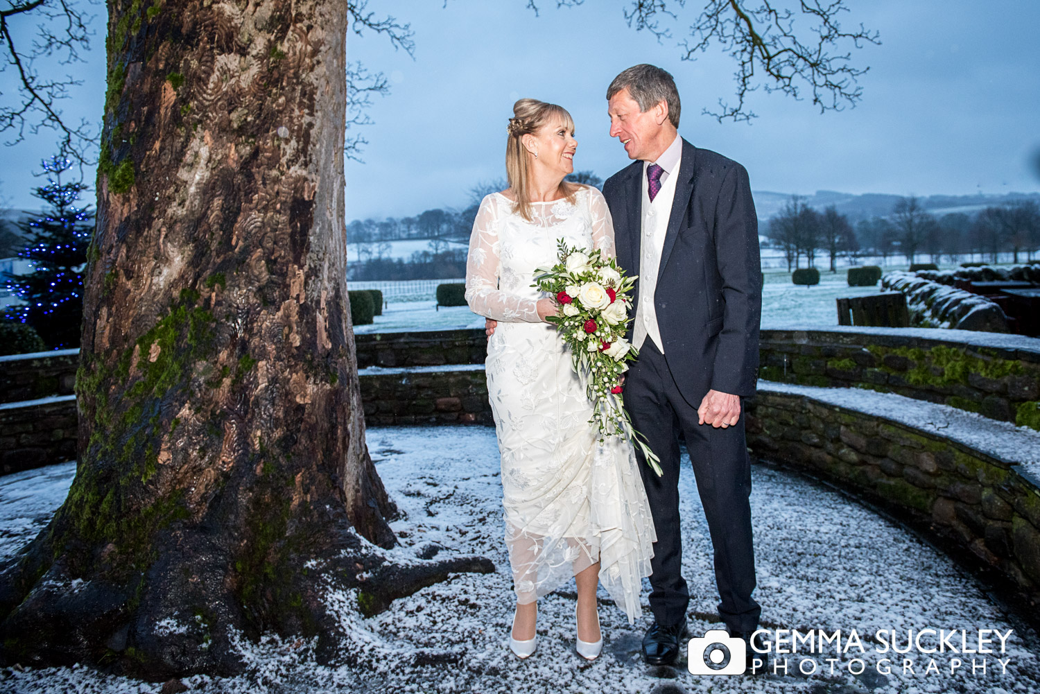 bride and groom in the snow outside The Devonshire arms in bolton Abbey