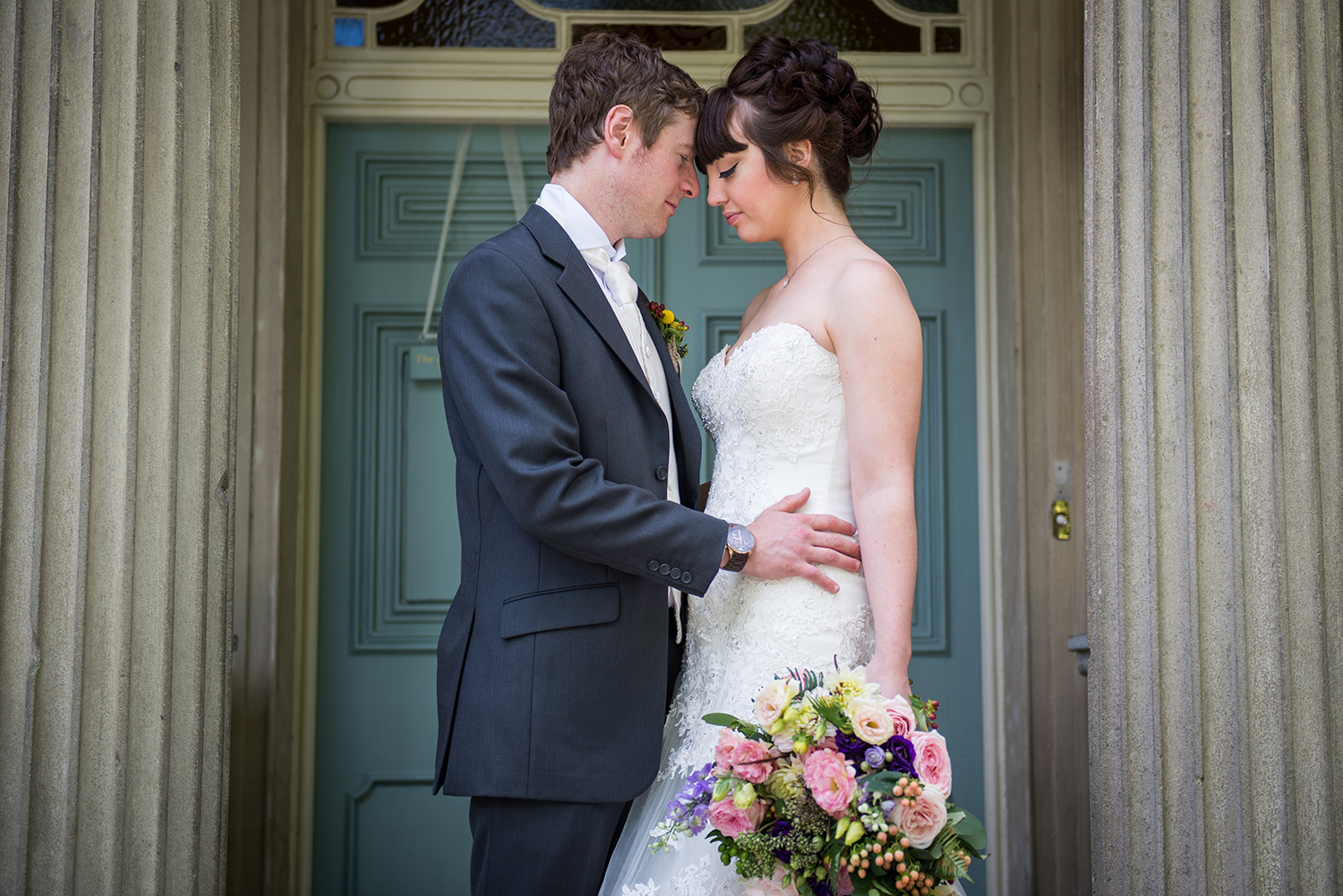 bride and groom hugging on the doorstep at taitlands in settle