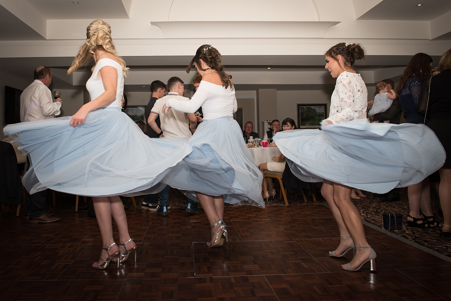 bridesmaids spinning on the dancefloor with their dresses flowing