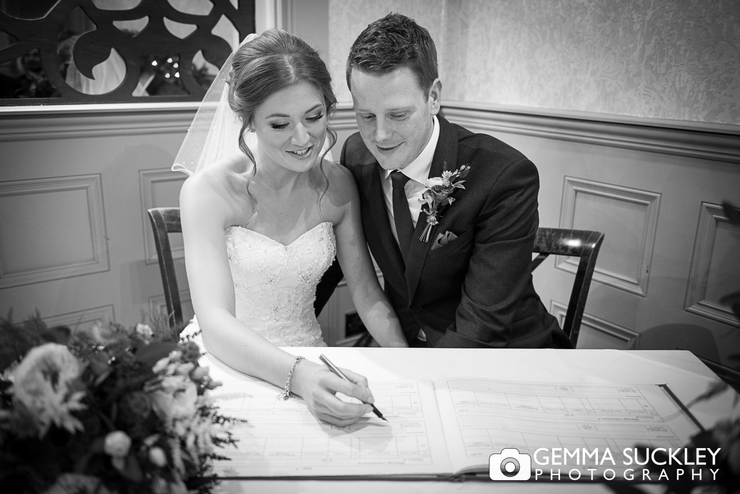 bride and groom signing the registrar