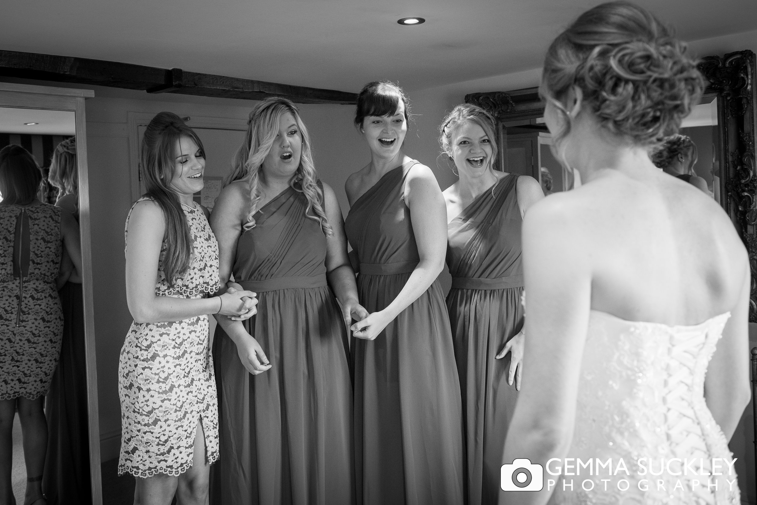 bridesmaids looking shocked as they see the bride