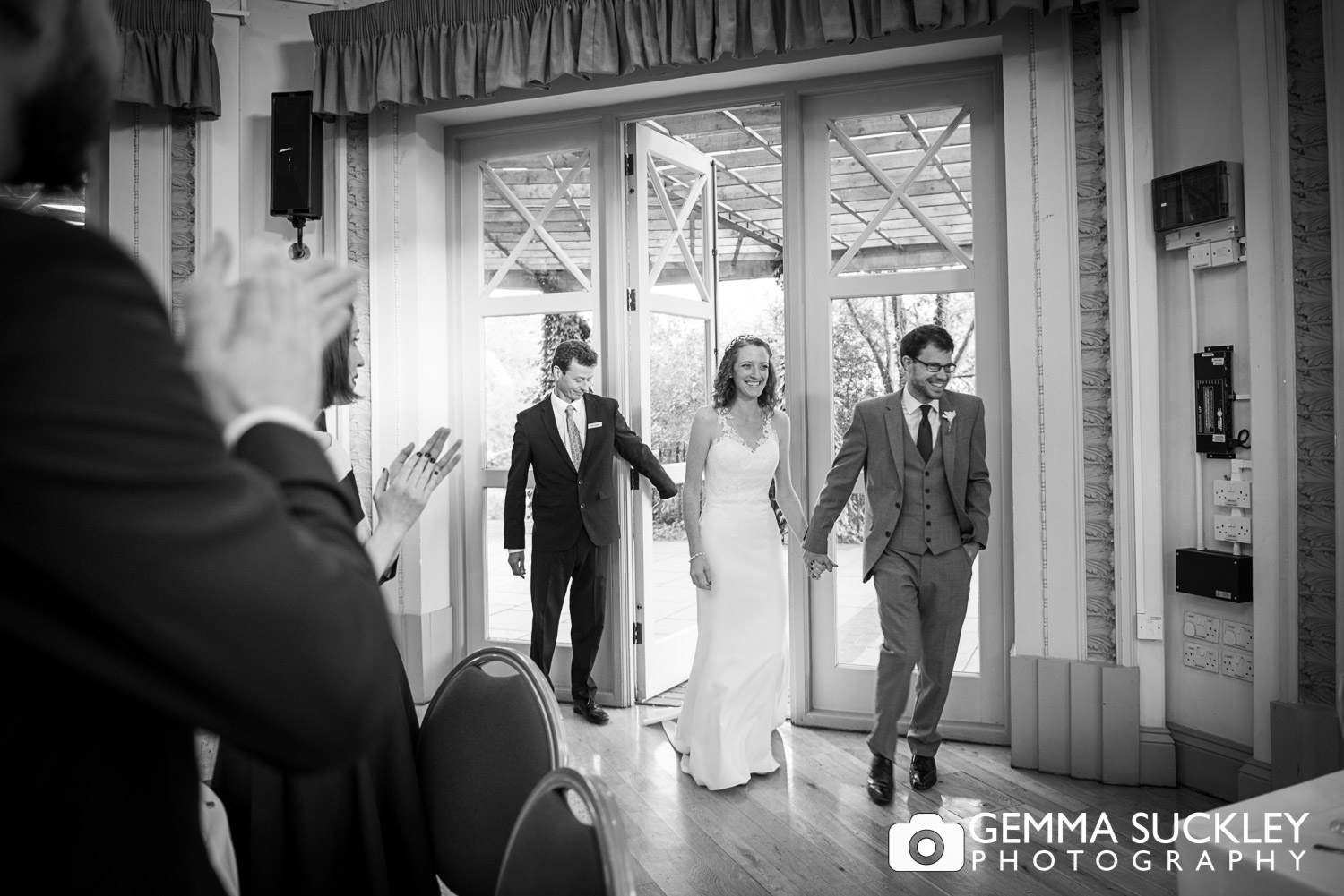 bride and groom walking through the sun pavilion doors in harrogate wedding venue