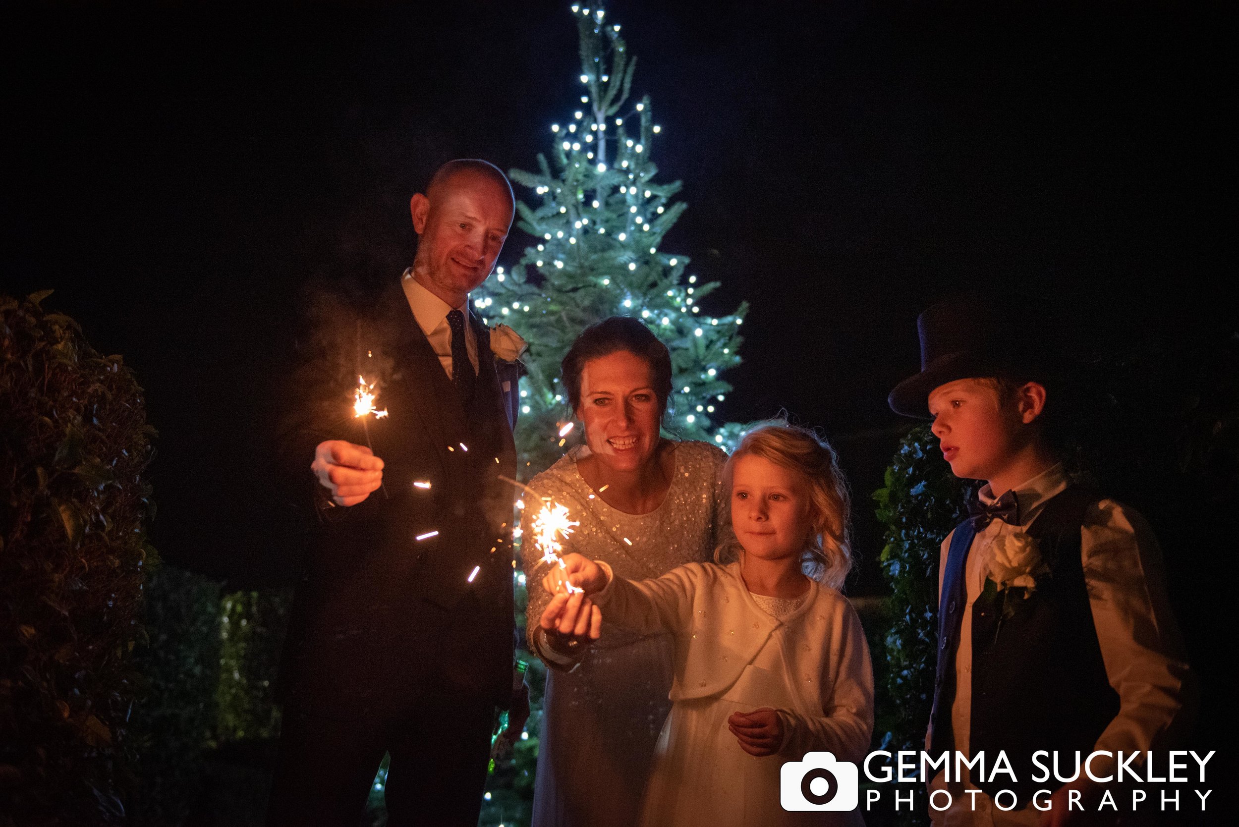 family holding sparklers at christmas wedding at the devonshire arms in bolton abbey