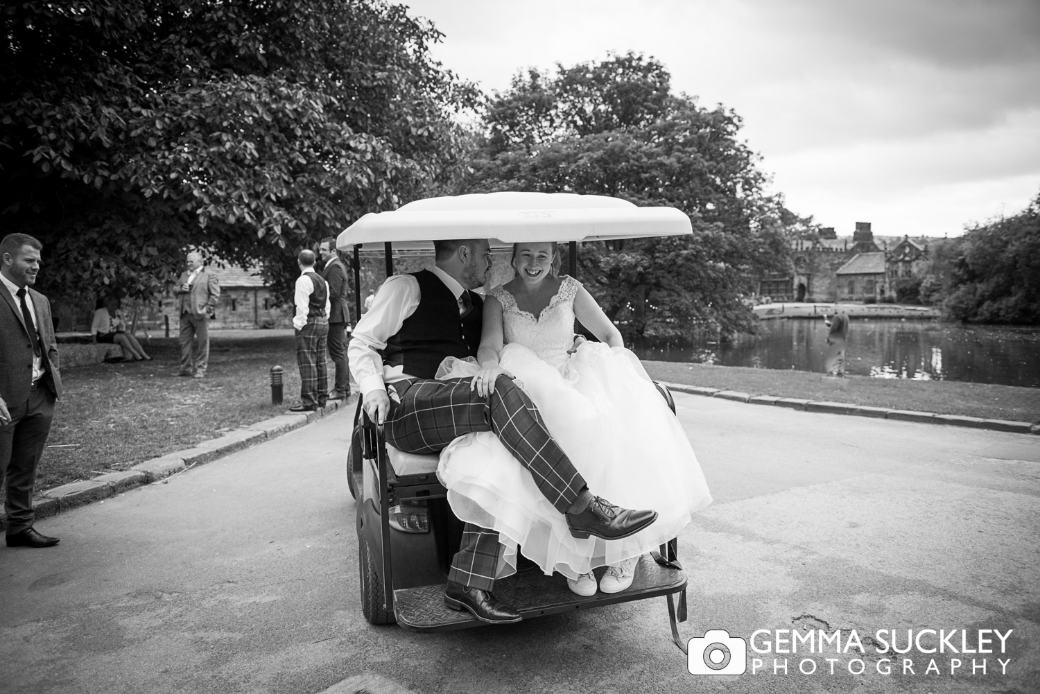 bride and groom in a golf buggy at east riddlesden hall