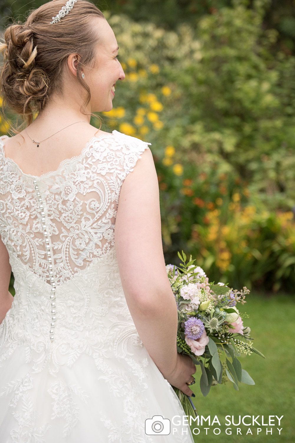 the back of a bride wedding dress detail in the garden at east riddlesden hall