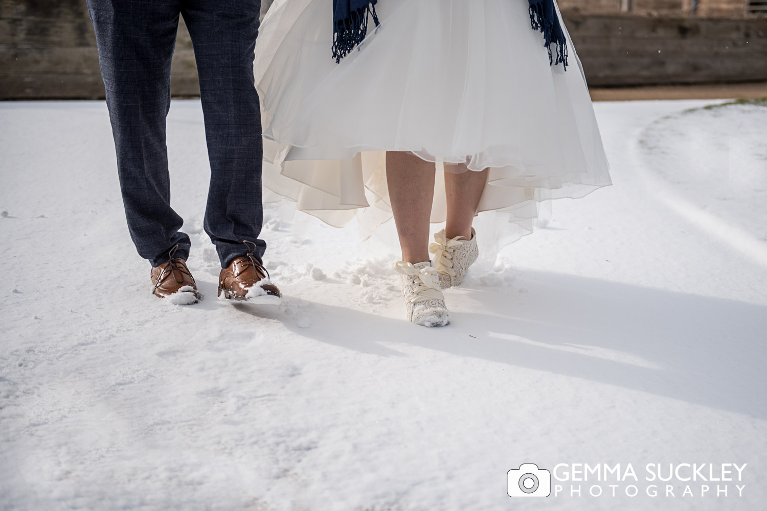 Bride and Groom's feet walking in the snow outside Utopia, Skipton