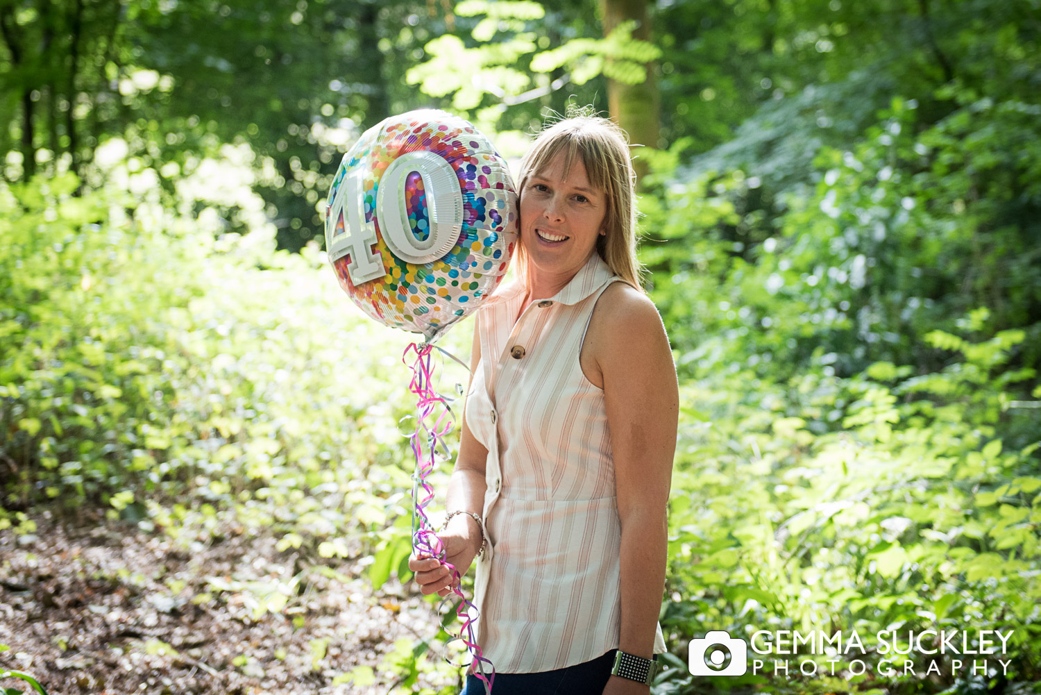 lady smiling with a 40th birthday balloon during a natural lifestyle photo shoot in skipton 