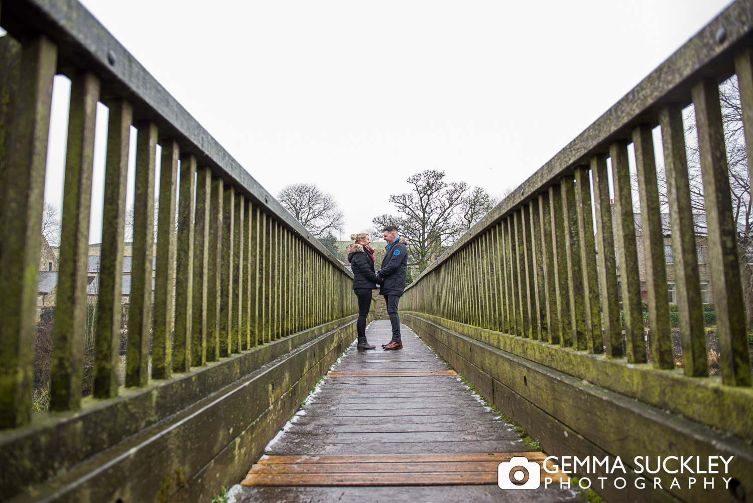 engaged couple holding hands on Linton Bridge during their engagement photo shoot 
